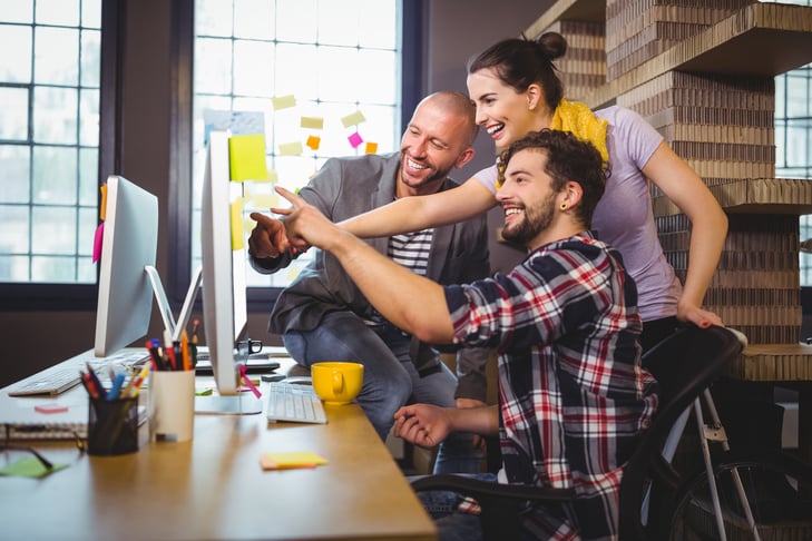 cheerful-business-people-pointing-computer